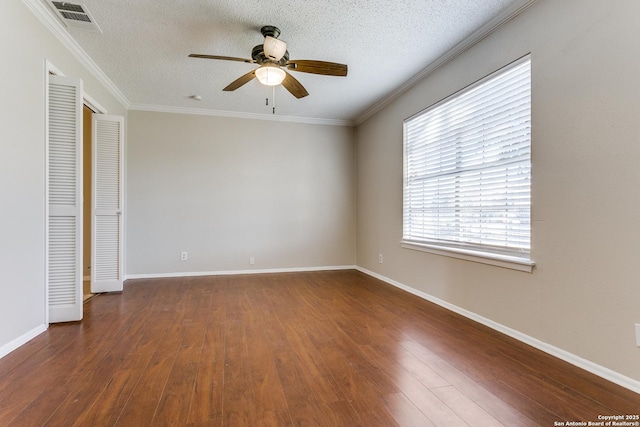 unfurnished bedroom featuring ceiling fan, a textured ceiling, dark hardwood / wood-style flooring, and crown molding