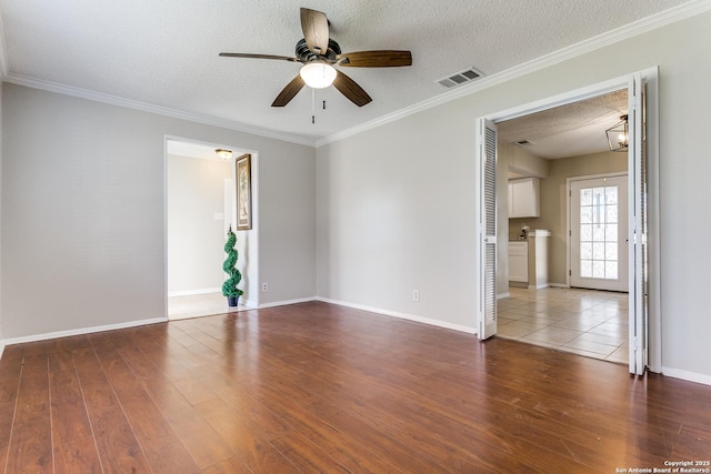 spare room with hardwood / wood-style flooring, a textured ceiling, crown molding, and ceiling fan