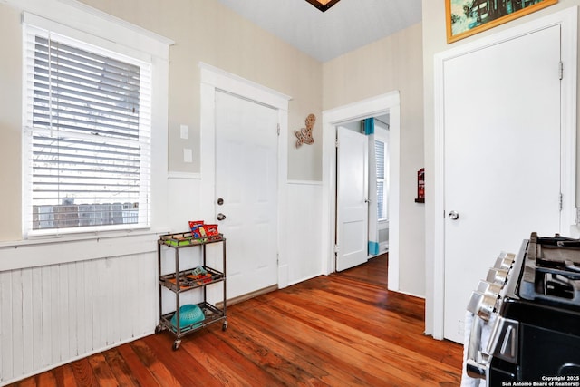 foyer entrance with radiator heating unit and wood-type flooring