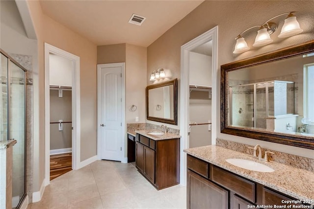 bathroom featuring a shower with shower door, tile patterned floors, and vanity