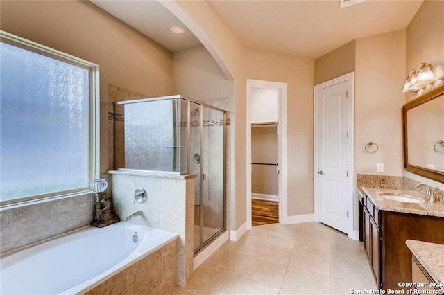 bathroom with independent shower and bath, a wealth of natural light, tile patterned floors, and vanity