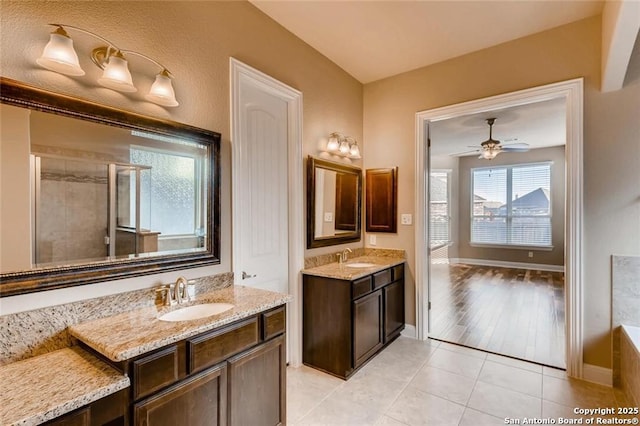 bathroom featuring vanity, a shower with shower door, ceiling fan, and tile patterned floors