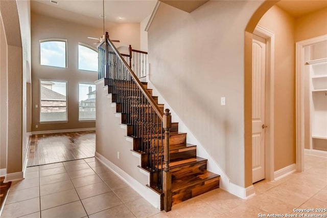 stairway with tile patterned floors and ceiling fan