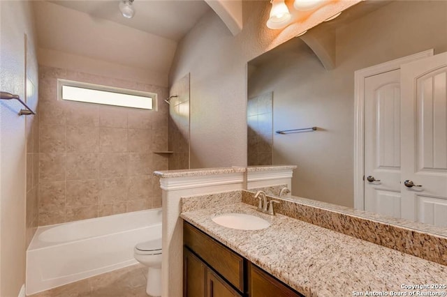 full bathroom with tiled shower / bath combo, toilet, tile patterned floors, and vanity