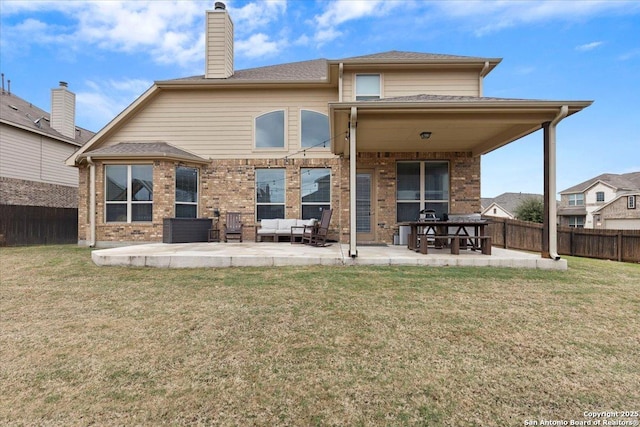 rear view of house with a patio, outdoor lounge area, and a yard