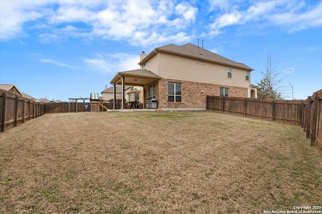 rear view of house with a playground and a yard