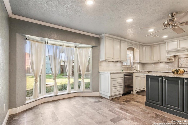 kitchen with decorative backsplash, a textured ceiling, white cabinets, and ornamental molding