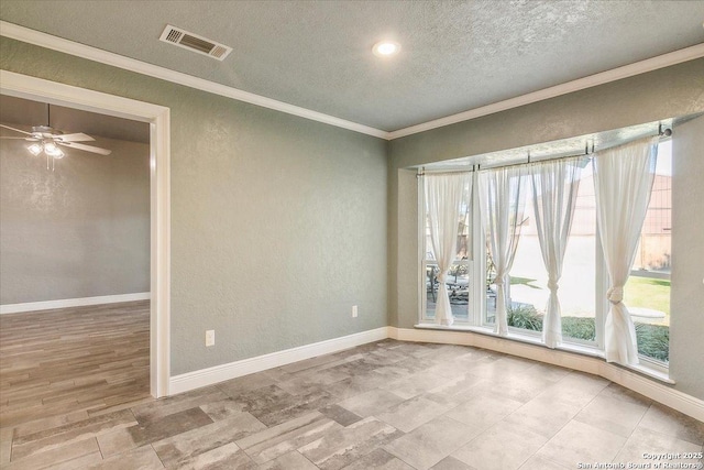 empty room featuring ceiling fan, crown molding, and a textured ceiling