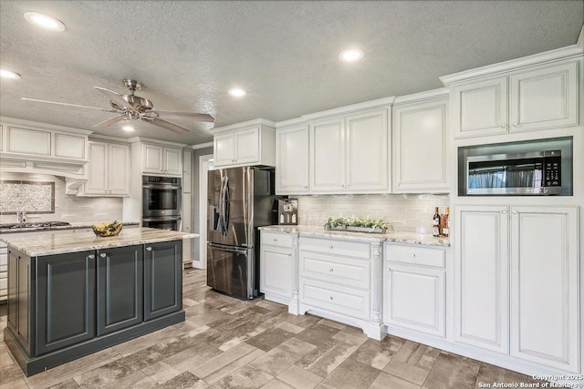 kitchen featuring a kitchen island, light stone counters, white cabinetry, and stainless steel appliances