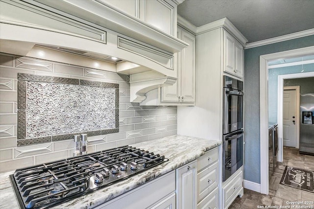 kitchen featuring decorative backsplash, light stone counters, appliances with stainless steel finishes, and crown molding