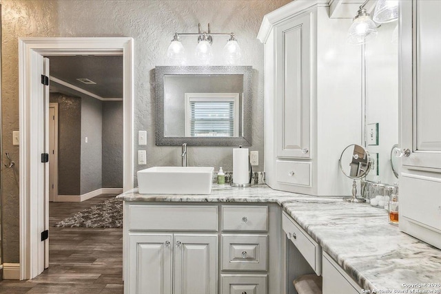 bathroom featuring hardwood / wood-style floors, vanity, and ornamental molding