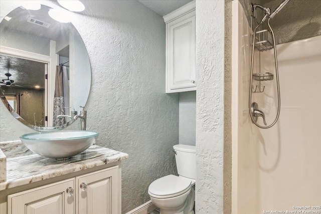 bathroom featuring vanity, toilet, and walk in shower