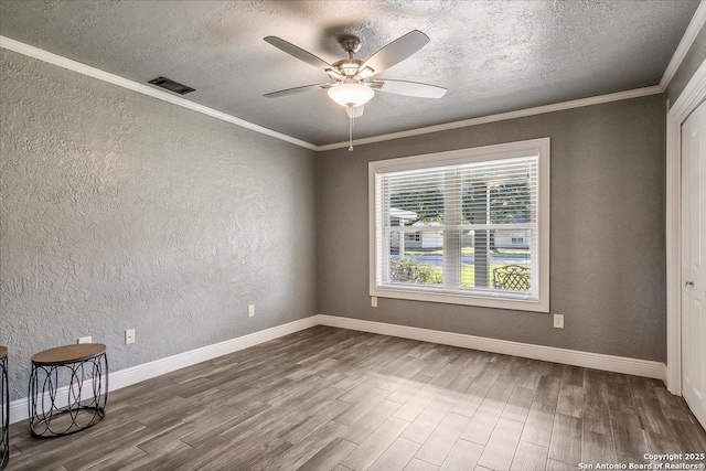 unfurnished room with ceiling fan, hardwood / wood-style floors, ornamental molding, and a textured ceiling