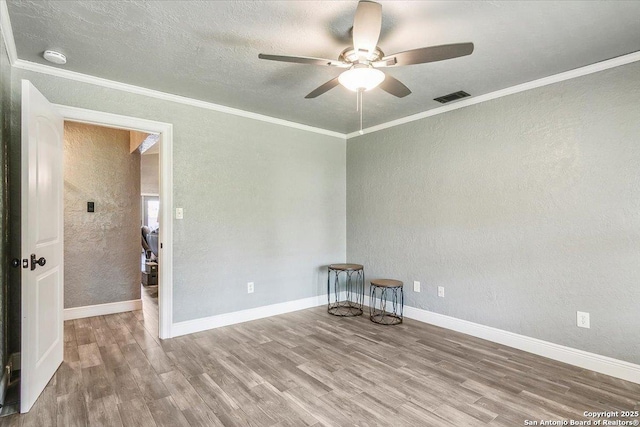 empty room featuring hardwood / wood-style flooring, a textured ceiling, ceiling fan, and ornamental molding