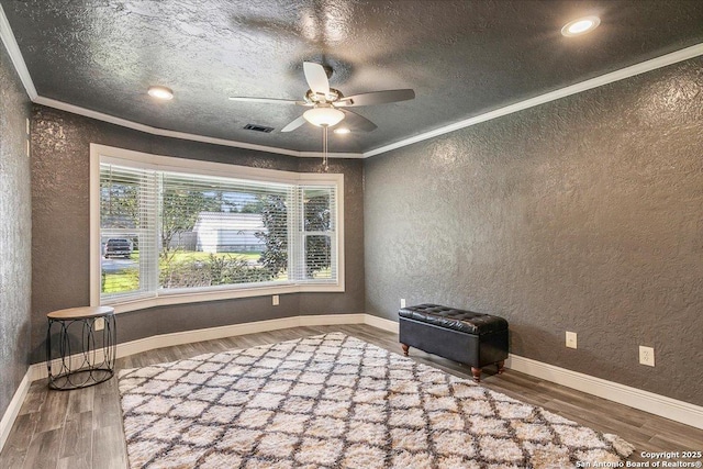 unfurnished room with ceiling fan, crown molding, and wood-type flooring