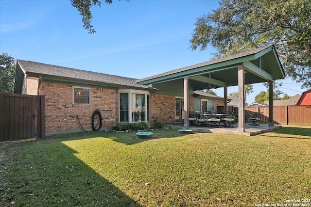 back of house with a patio area and a yard