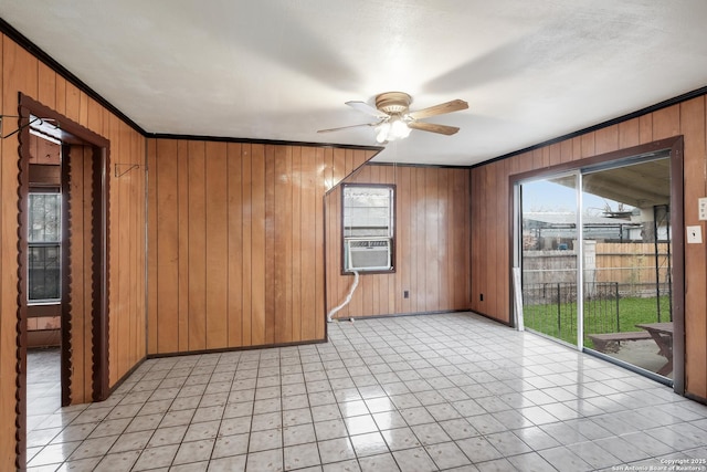 unfurnished room featuring ceiling fan, wood walls, ornamental molding, and cooling unit