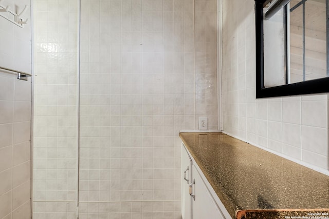 bathroom featuring vanity and tile walls