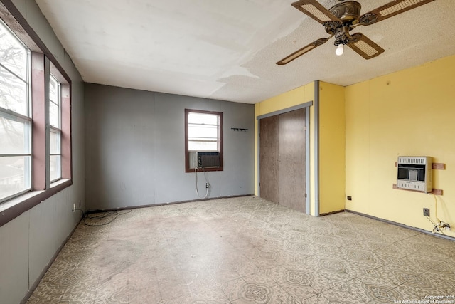 unfurnished bedroom featuring a textured ceiling, cooling unit, a closet, ceiling fan, and heating unit