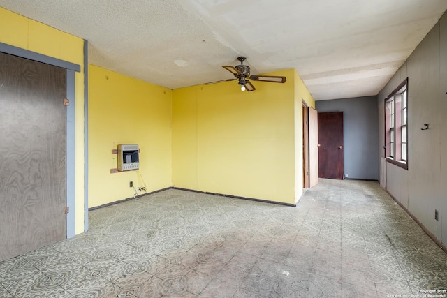 spare room featuring heating unit, ceiling fan, and a textured ceiling