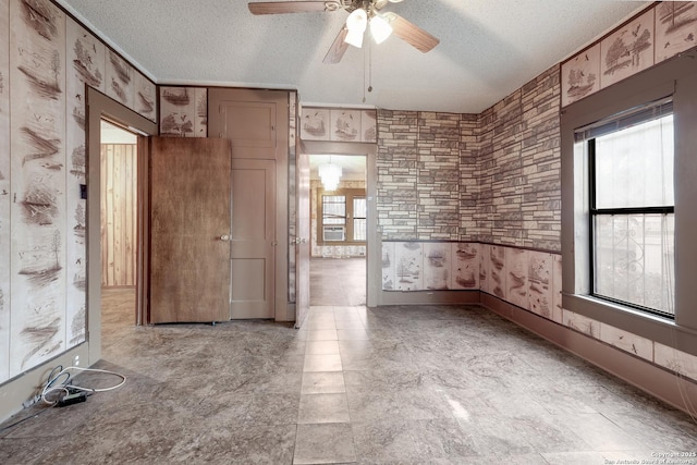 empty room with a textured ceiling and a wealth of natural light