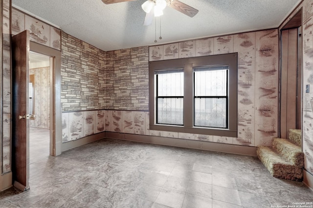 spare room with a textured ceiling and ceiling fan