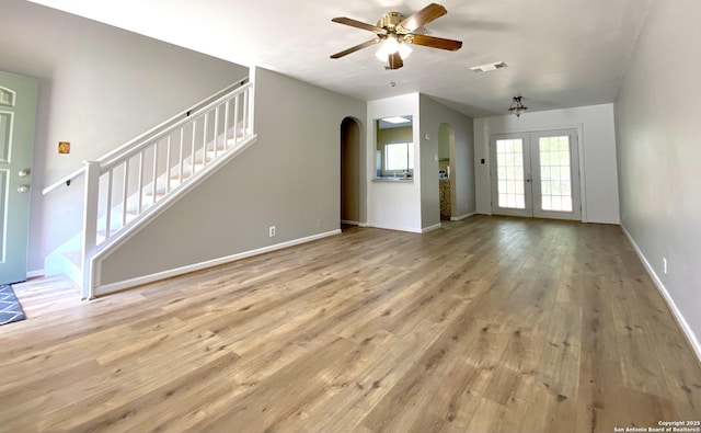 unfurnished living room featuring ceiling fan, french doors, and light wood-type flooring