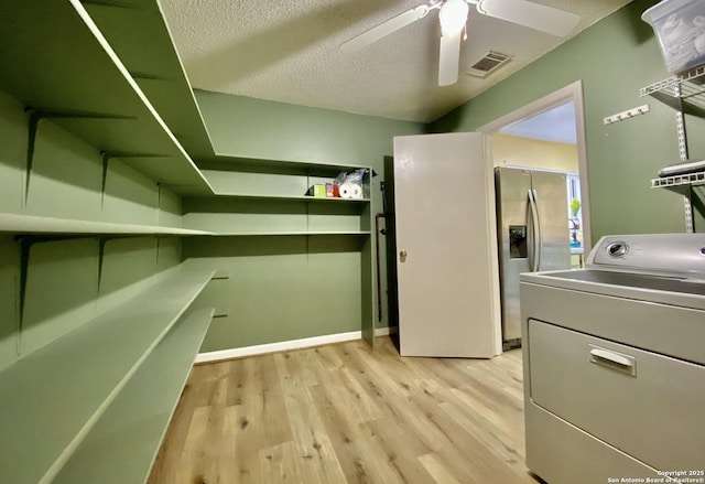 washroom featuring ceiling fan, washer / dryer, light hardwood / wood-style flooring, and a textured ceiling