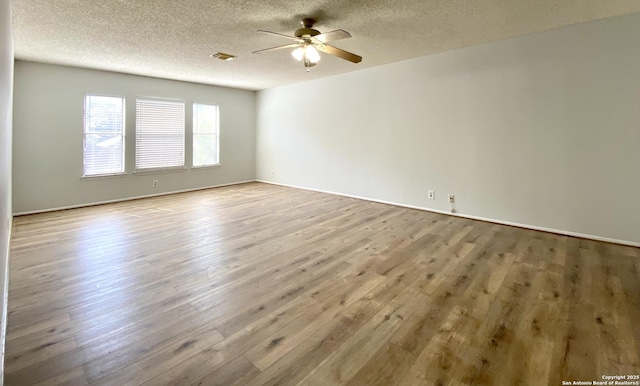 spare room with ceiling fan, a textured ceiling, and light hardwood / wood-style flooring