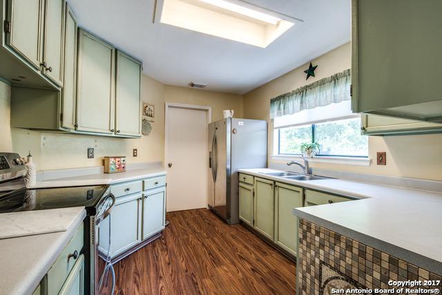 kitchen featuring sink, dark hardwood / wood-style floors, green cabinetry, and appliances with stainless steel finishes