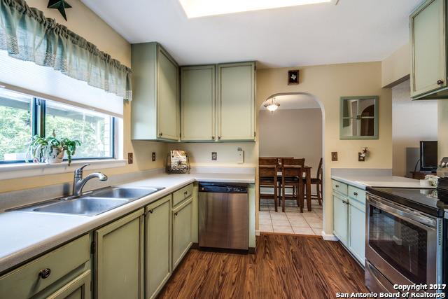 kitchen featuring stainless steel appliances, green cabinets, and dark hardwood / wood-style flooring