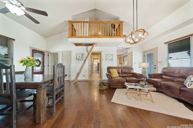 living room featuring ceiling fan with notable chandelier, dark wood-type flooring, high vaulted ceiling, and a healthy amount of sunlight