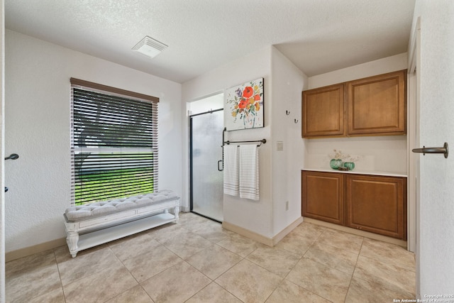 kitchen with a textured ceiling and light tile patterned floors