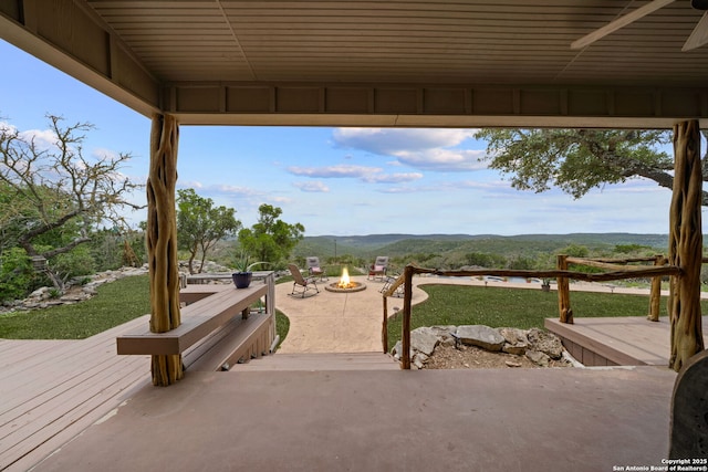 view of patio / terrace featuring ceiling fan, an outdoor fire pit, and a deck with mountain view