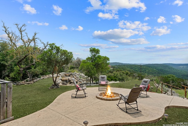 view of patio with a mountain view and an outdoor fire pit