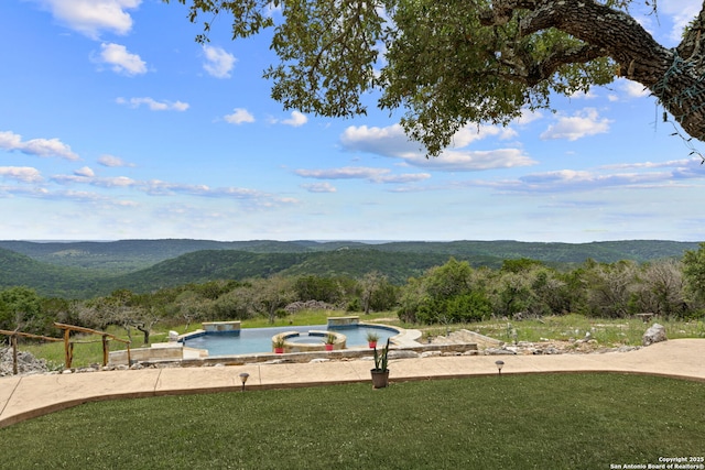 view of swimming pool featuring a mountain view and a yard