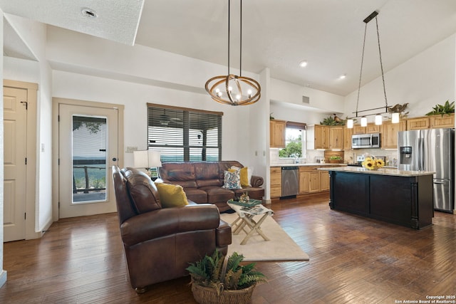 living room with high vaulted ceiling, dark hardwood / wood-style floors, and a chandelier