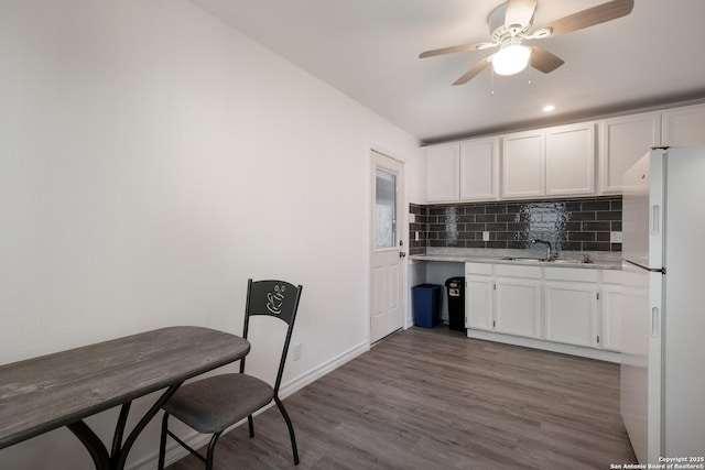 kitchen featuring white cabinets, white refrigerator, dark hardwood / wood-style flooring, tasteful backsplash, and sink