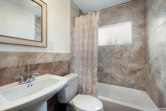 full bathroom featuring sink, toilet, tile walls, and shower / bathtub combination with curtain