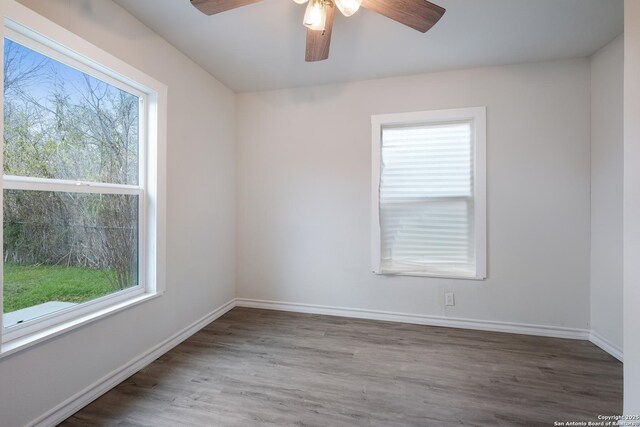 empty room with hardwood / wood-style flooring, ceiling fan, and plenty of natural light