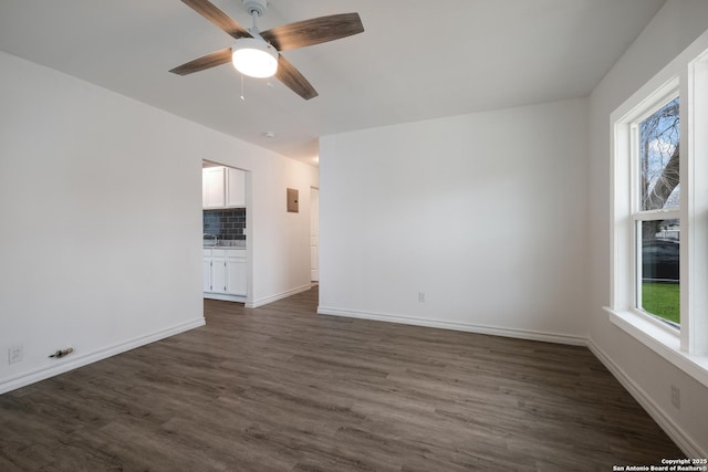 unfurnished room featuring sink, ceiling fan, and dark hardwood / wood-style floors