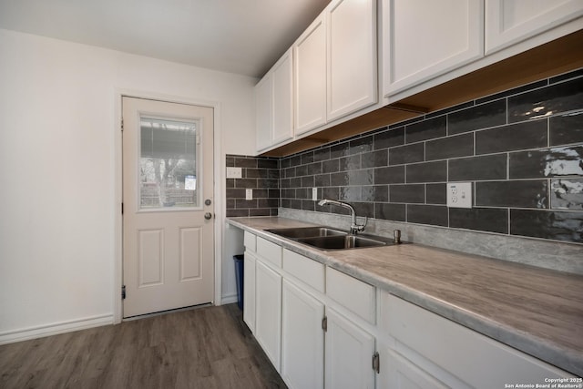 kitchen with white cabinets, backsplash, dark wood-type flooring, and sink