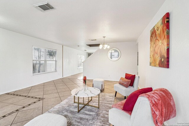 living room with tile patterned floors and an inviting chandelier