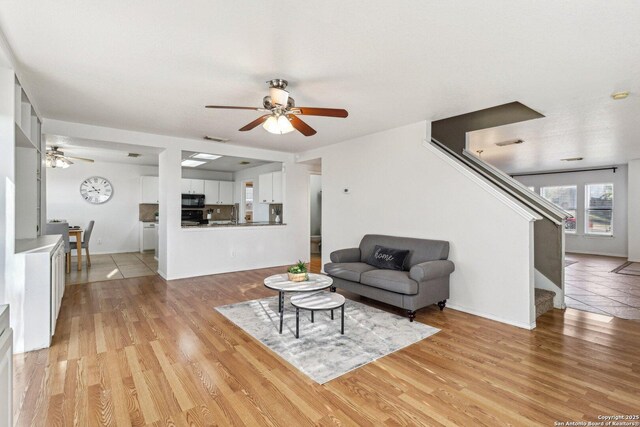 living room featuring ceiling fan and light hardwood / wood-style flooring