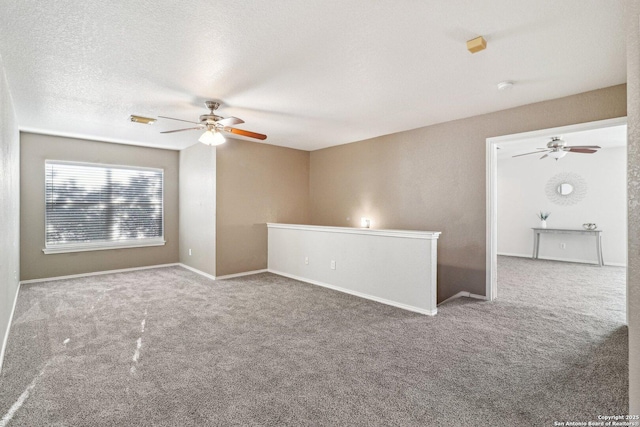 spare room featuring carpet floors, a textured ceiling, and ceiling fan