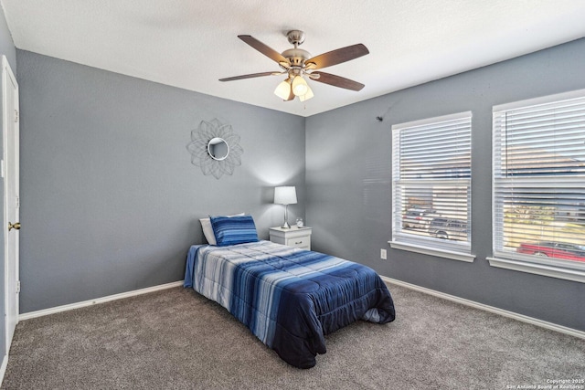 bedroom featuring ceiling fan and dark carpet