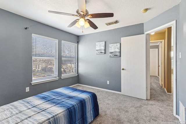 bedroom featuring carpet, a textured ceiling, and ceiling fan