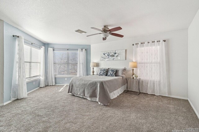 bedroom featuring ceiling fan, carpet floors, and multiple windows