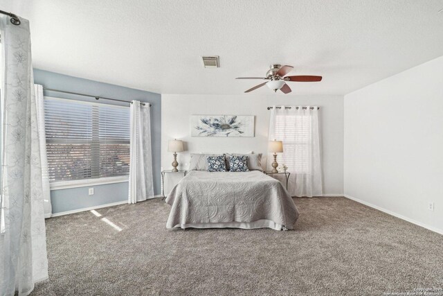 carpeted bedroom featuring a textured ceiling and ceiling fan