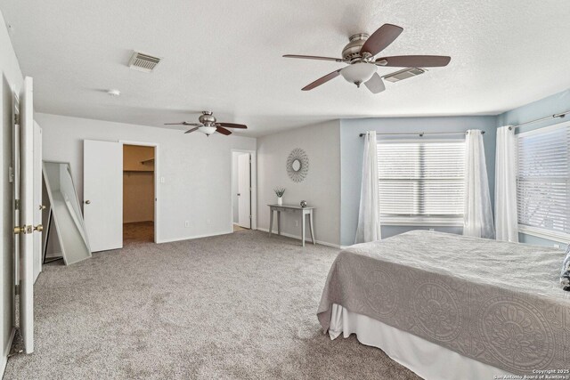 bedroom featuring light carpet, a textured ceiling, and ceiling fan